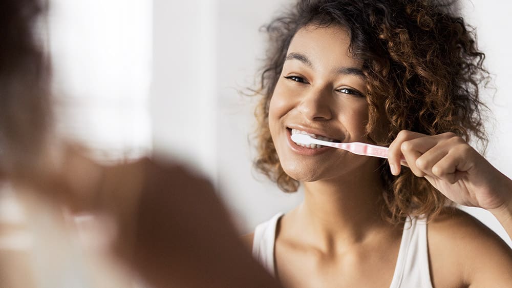 Borsta tänderna minst två gånger om dagen eller enligt anvisningar från en tandläkare eller tandhygienist.