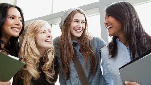 four female student smiling next to each other